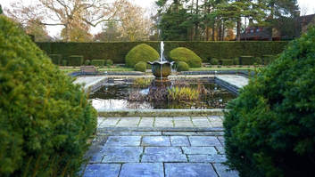 Garden fountain with surrounding hedges
